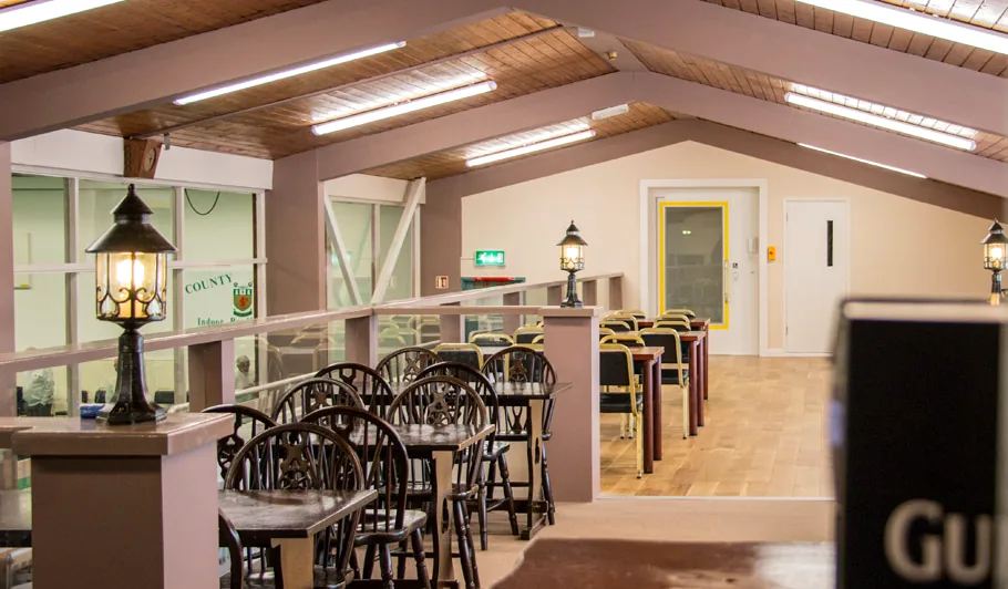 The Bar Lounge, tables set quietly along a rail overlooking the greens