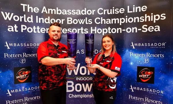 Two club players holding their trophies at the World Indoor Bowls Championships