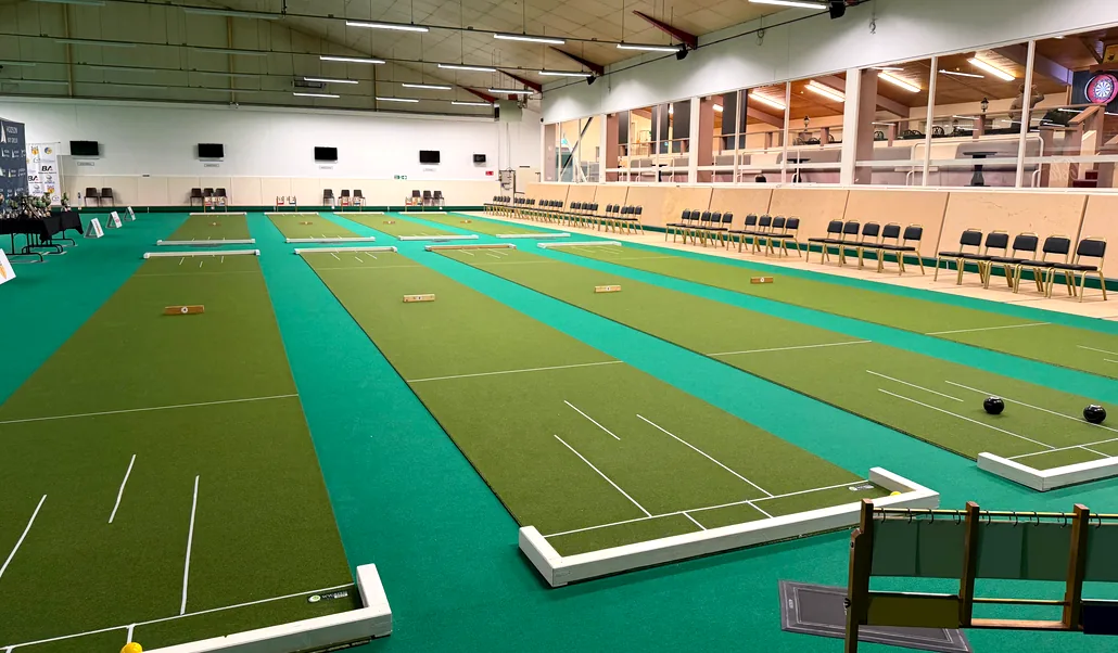 Match mats laid out the length of the stadium floor, with spectator seating down one side