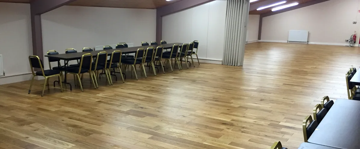 The McConkey Room, tables and chairs down one side of a wide wooden floor