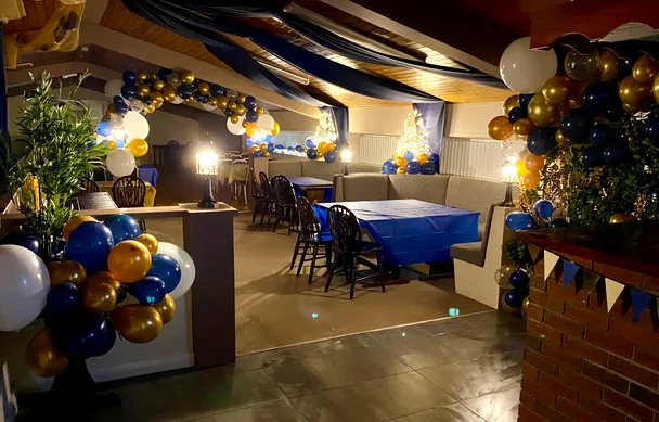 The bar dressed for a party, with balloon arches and draped ceiling